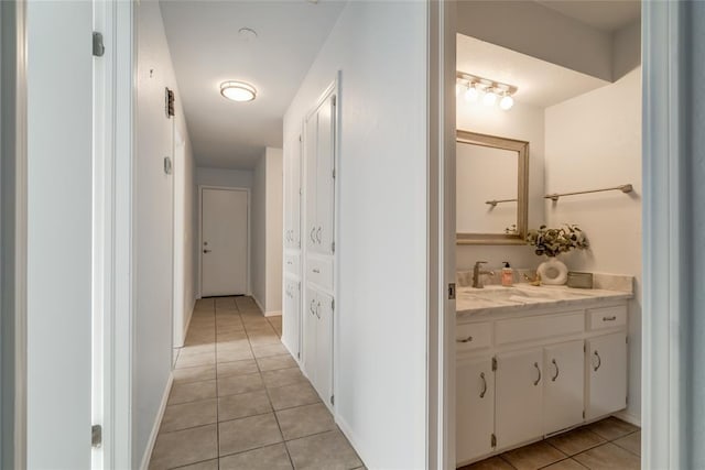 2408 Cypress Ct, Edmond, OK 73013 - corridor featuring light tile patterned flooring, a sink, and baseboards