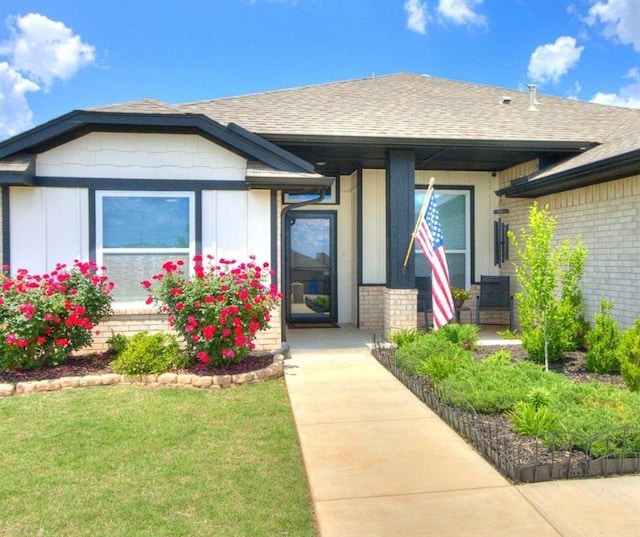 3819 Mistwood Pl, Norman, OK 73026 - view of front of property with brick siding, a shingled roof, a front yard, and a porch