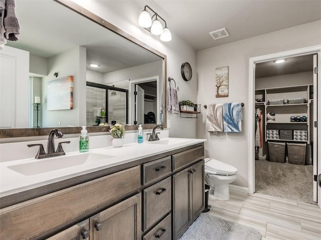 3819 Mistwood Pl, Norman, OK 73026 - bathroom featuring double vanity, a spacious closet, a stall shower, and toilet