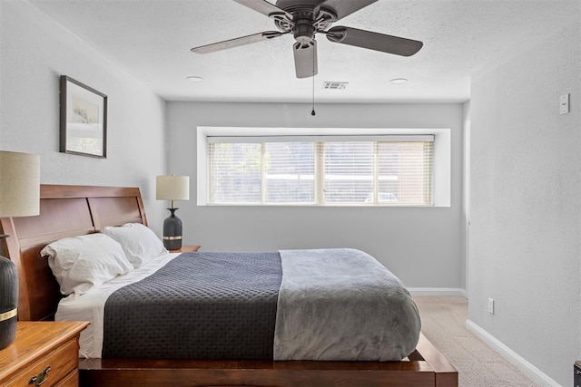 bedroom with visible vents, baseboards, ceiling fan, and light colored carpet