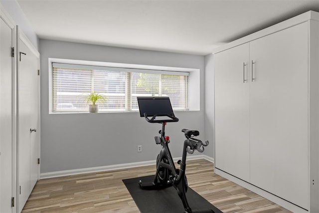 exercise room featuring light wood-style floors and baseboards