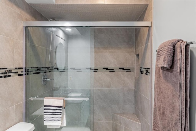 bathroom with toilet and a shower stall