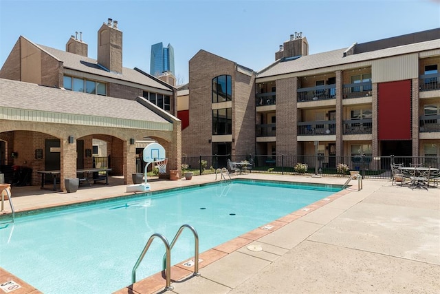 community pool featuring a patio area and fence