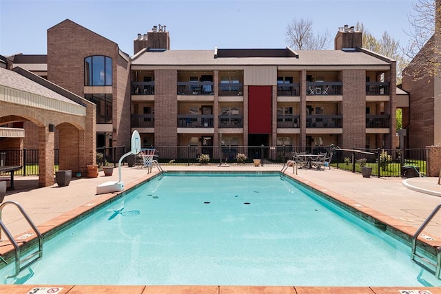 view of swimming pool with fence and a patio