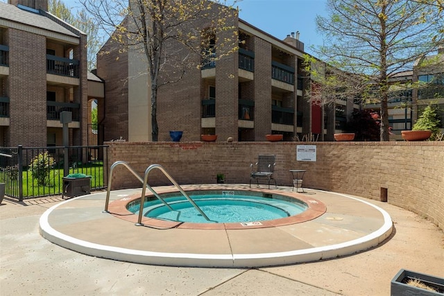 view of pool featuring fence and a community hot tub