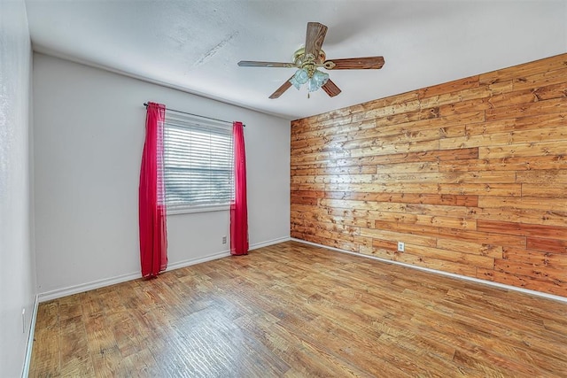 17421 E 1160th Rd, Sweetwater, OK 73666 - spare room featuring wooden walls, baseboards, ceiling fan, and wood finished floors