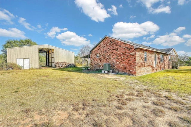 17421 E 1160th Rd, Sweetwater, OK 73666 - view of side of home with brick siding, central AC unit, an outbuilding, and a yard