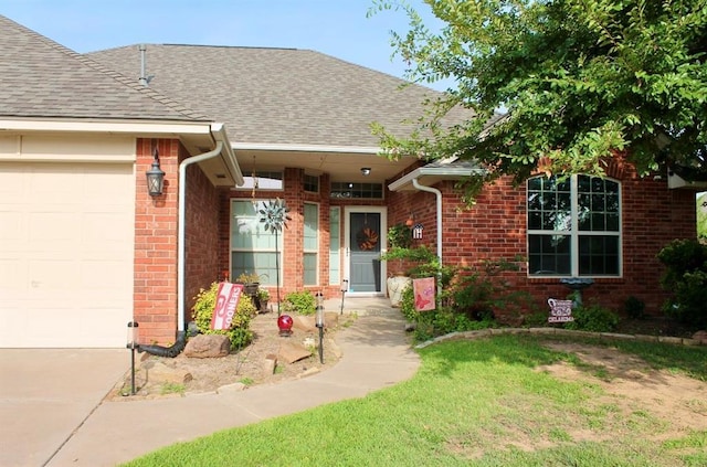 doorway to property with a garage, brick siding, and roof with shingles