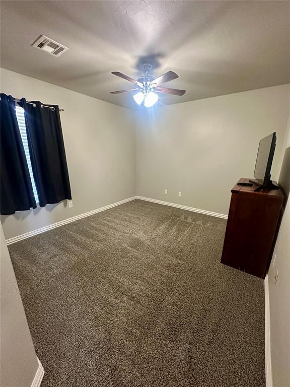 unfurnished bedroom featuring visible vents, baseboards, ceiling fan, and carpet flooring