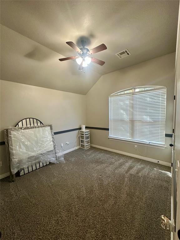 unfurnished bedroom with visible vents, carpet, baseboards, ceiling fan, and vaulted ceiling