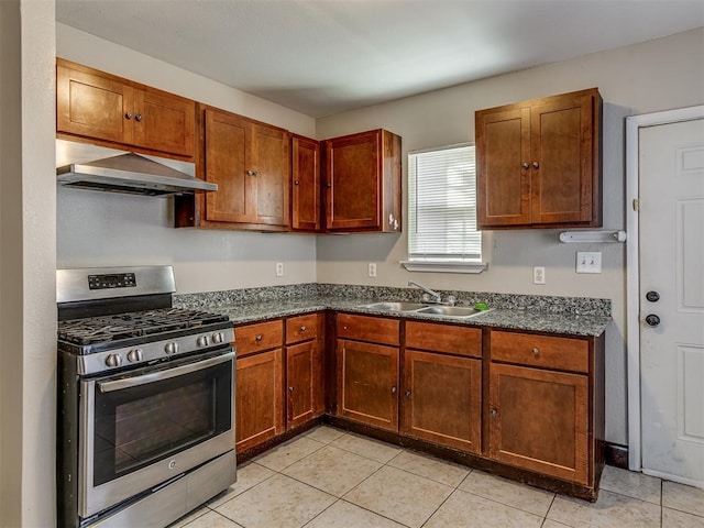 3604 NW 27th St, Oklahoma City, OK 73107 - kitchen with brown cabinetry, stainless steel range with gas cooktop, light tile patterned flooring, wall chimney exhaust hood, and a sink