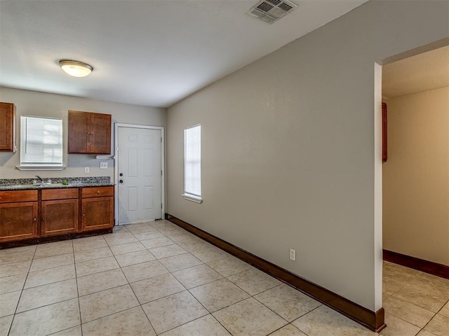 3604 NW 27th St, Oklahoma City, OK 73107 - kitchen featuring light tile patterned floors, visible vents, baseboards, and a sink