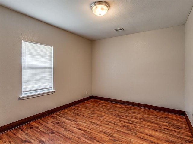 3604 NW 27th St, Oklahoma City, OK 73107 - unfurnished room with visible vents, a textured ceiling, baseboards, and wood finished floors