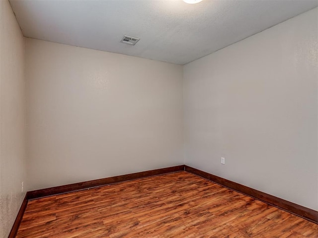 3604 NW 27th St, Oklahoma City, OK 73107 - empty room with a textured ceiling, wood finished floors, visible vents, and baseboards