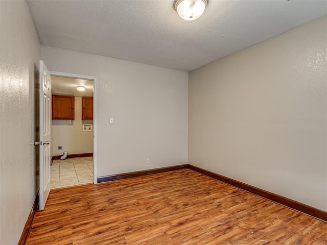 3604 NW 27th St, Oklahoma City, OK 73107 - empty room featuring light wood-style flooring, a textured ceiling, and baseboards