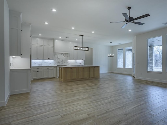 2292 NW 34th St, Newcastle, OK 73065 - kitchen featuring a chandelier, open floor plan, baseboards, light wood-type flooring, and ceiling fan