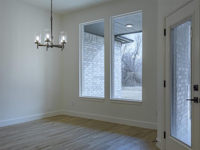 2292 NW 34th St, Newcastle, OK 73065 - unfurnished dining area with wood finished floors, a chandelier, and baseboards