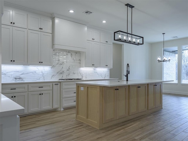2292 NW 34th St, Newcastle, OK 73065 - kitchen with a chandelier, a sink, backsplash, light countertops, and light wood-style flooring