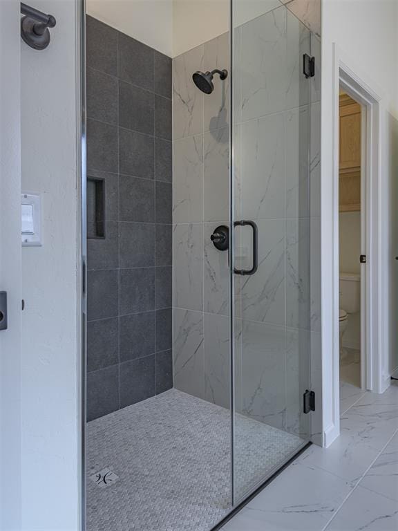 2292 NW 34th St, Newcastle, OK 73065 - bathroom with marble look tiles, a stall shower, and toilet