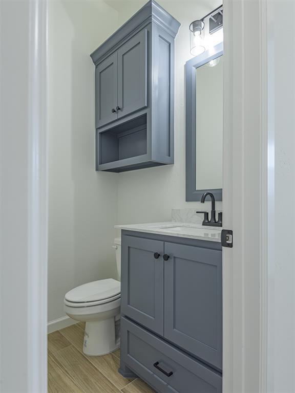 2292 NW 34th St, Newcastle, OK 73065 - half bath featuring toilet, vanity, wood finished floors, and baseboards
