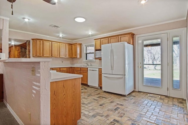kitchen with white appliances, light countertops, brick floor, and ornamental molding