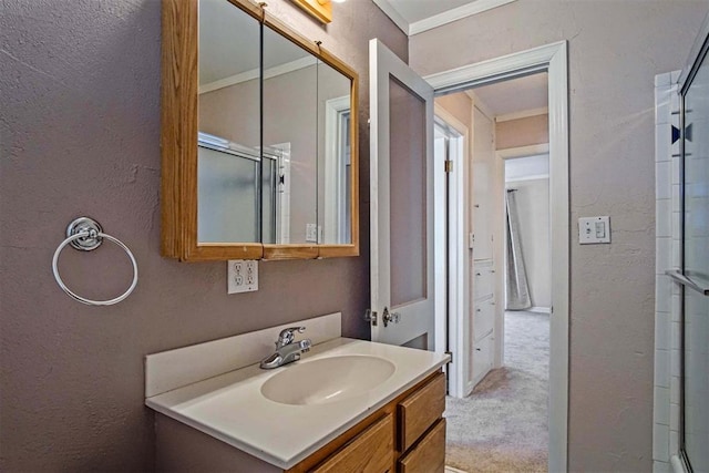 bathroom with an enclosed shower, vanity, and a textured wall
