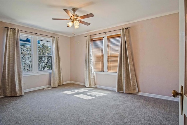 carpeted spare room with visible vents, baseboards, ceiling fan, and ornamental molding