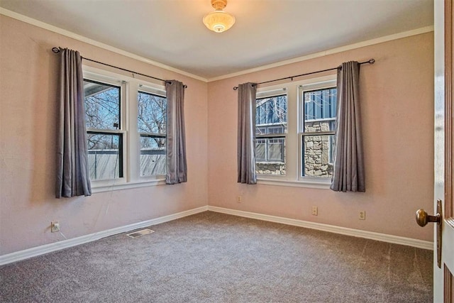 carpeted empty room with visible vents, baseboards, and ornamental molding