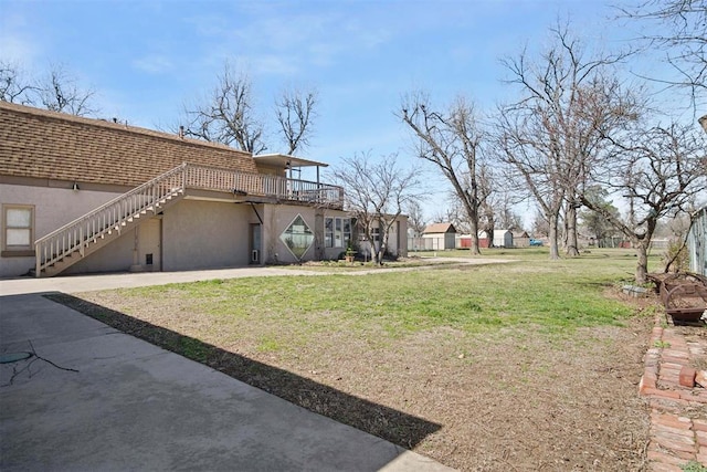 view of yard featuring a wooden deck and stairs