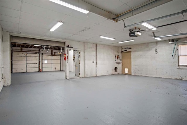 garage with concrete block wall and a garage door opener