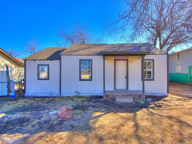 view of front of property with a shingled roof and fence