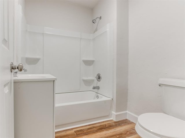 bathroom featuring baseboards, toilet, wood finished floors, and  shower combination