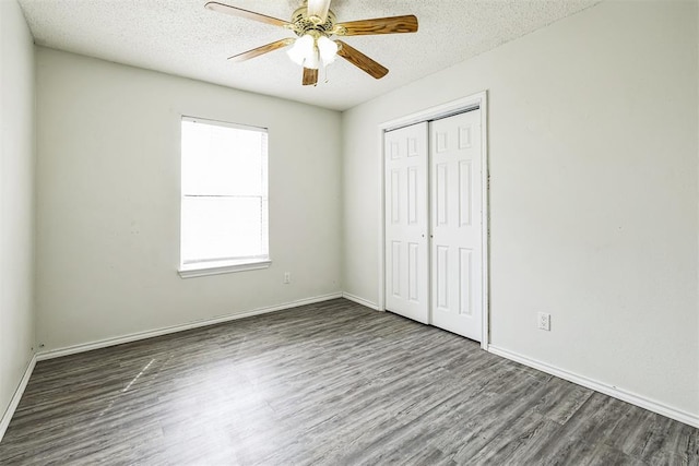 unfurnished bedroom with baseboards, wood finished floors, a closet, and a textured ceiling