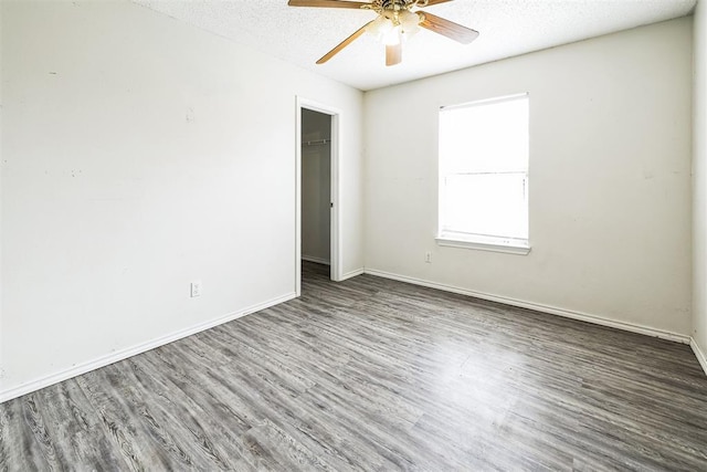 unfurnished bedroom featuring baseboards, wood finished floors, a closet, a textured ceiling, and a ceiling fan