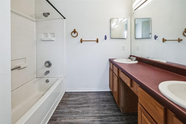 bathroom featuring double vanity, wood finished floors,  shower combination, and a sink
