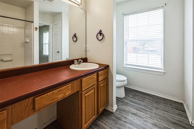 bathroom featuring visible vents, baseboards, toilet, wood finished floors, and vanity