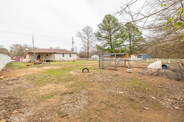 view of yard featuring an outbuilding and fence