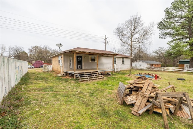rear view of house featuring an outbuilding, a yard, a fenced backyard, and a storage unit