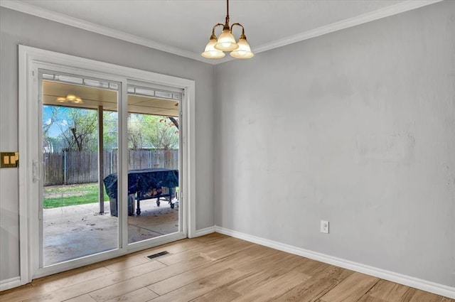 2008 Powderhorn, Edmond, OK 73034 - unfurnished room featuring a notable chandelier, light wood-style floors, and ornamental molding