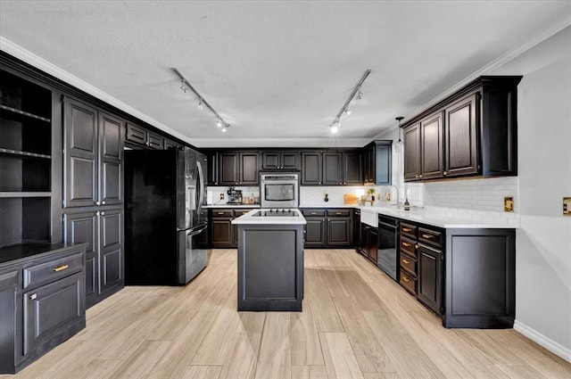 2008 Powderhorn, Edmond, OK 73034 - kitchen featuring a kitchen island, ornamental molding, decorative backsplash, black appliances, and light countertops