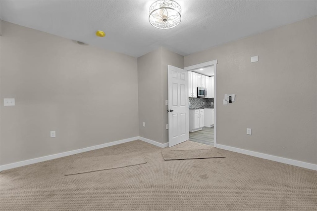 311 N 7th St, Sayre, OK 73662 - empty room with light colored carpet and a textured ceiling
