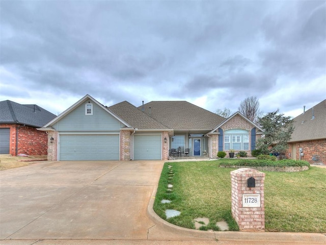 view of front of home with a front yard, concrete driveway, brick siding, and a garage