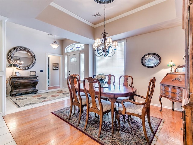 dining space with visible vents, crown molding, baseboards, a chandelier, and light wood-style flooring