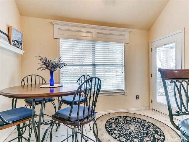 dining space featuring vaulted ceiling, light tile patterned flooring, and baseboards