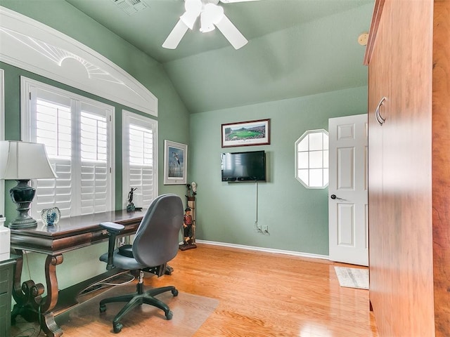 office space featuring light wood finished floors, visible vents, baseboards, ceiling fan, and vaulted ceiling