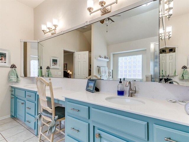 bathroom with tile patterned floors, a ceiling fan, vanity, and vaulted ceiling