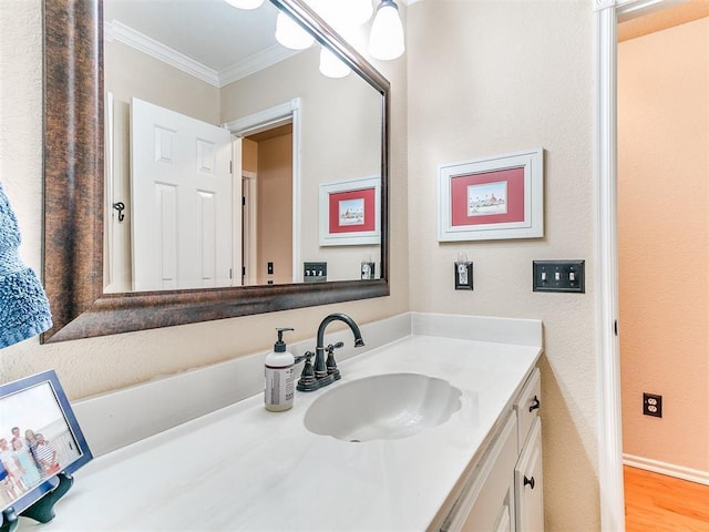 bathroom with vanity, wood finished floors, and ornamental molding