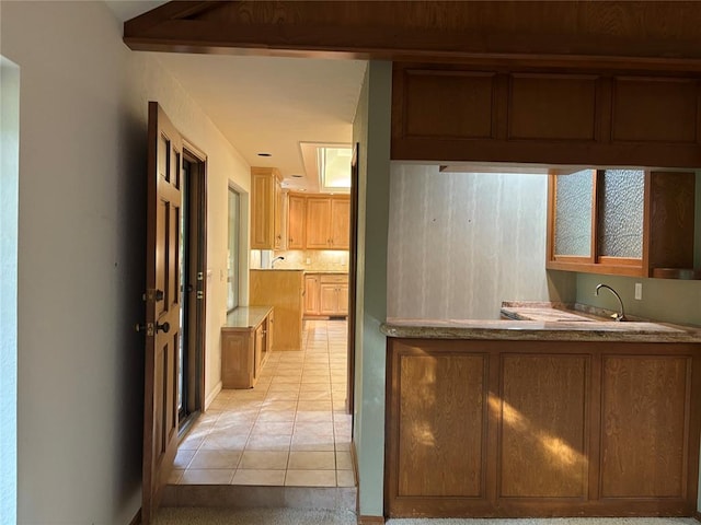 2001 Woodhill Rd, Edmond, OK 73025 - interior space with a sink, light tile patterned floors, brown cabinets, and light countertops