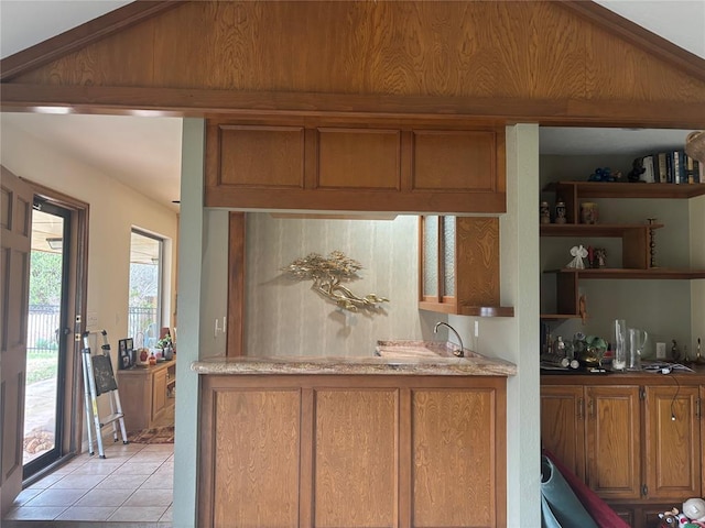 2001 Woodhill Rd, Edmond, OK 73025 - kitchen featuring open shelves, light tile patterned floors, and brown cabinetry