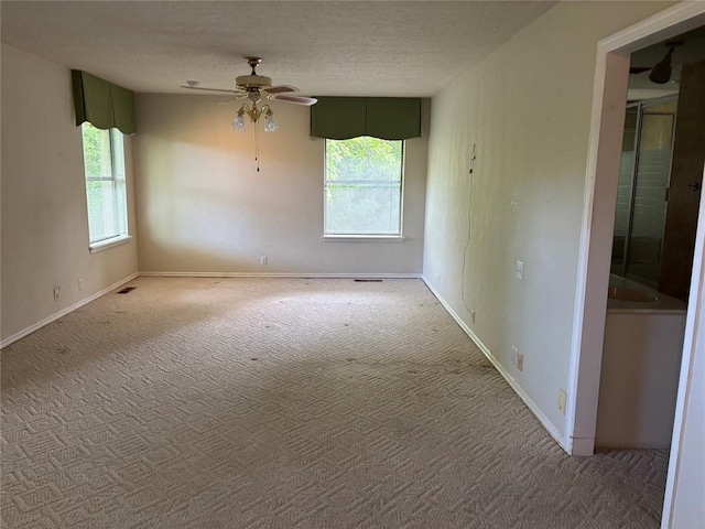 2001 Woodhill Rd, Edmond, OK 73025 - carpeted spare room with baseboards, a ceiling fan, a textured ceiling, and visible vents